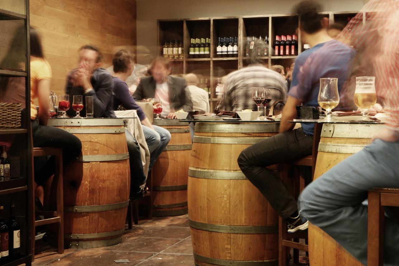 people seated in a bar drinking wine