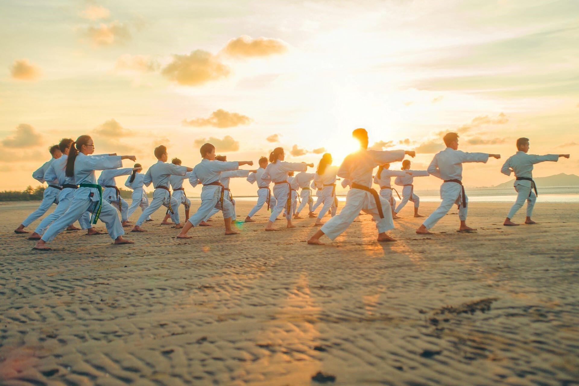 People doing karate on the beach.