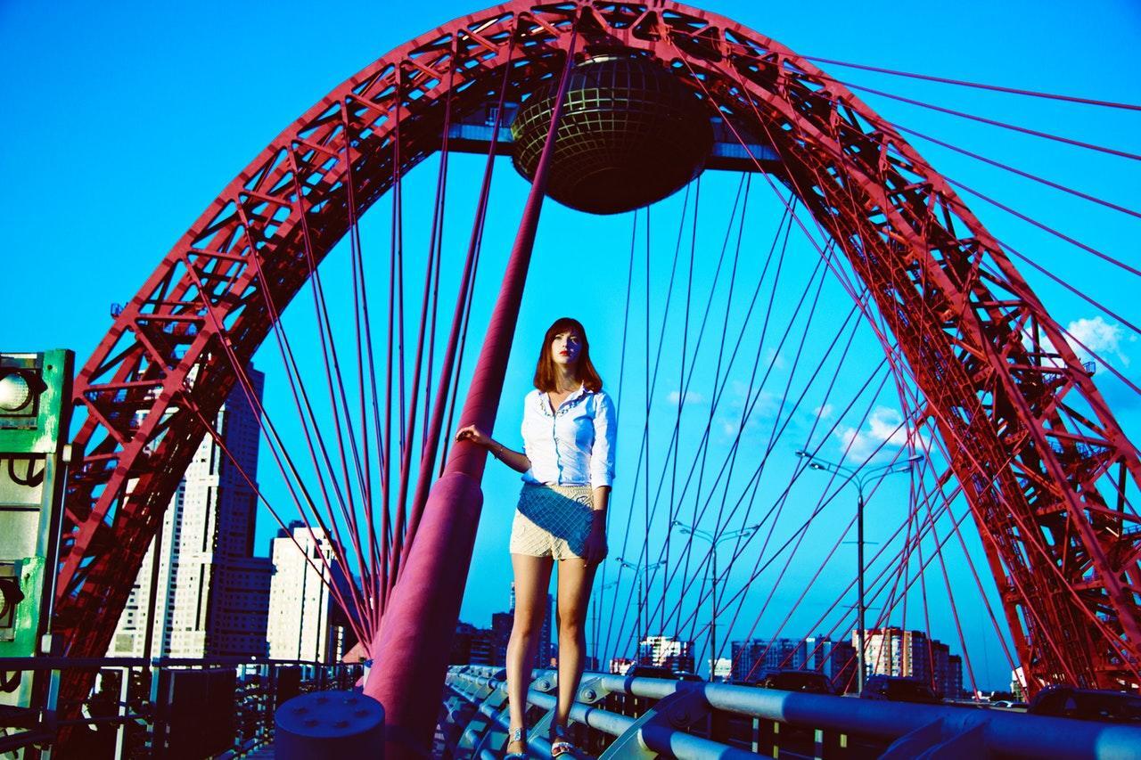 a woman standing under a ride at a theme park
