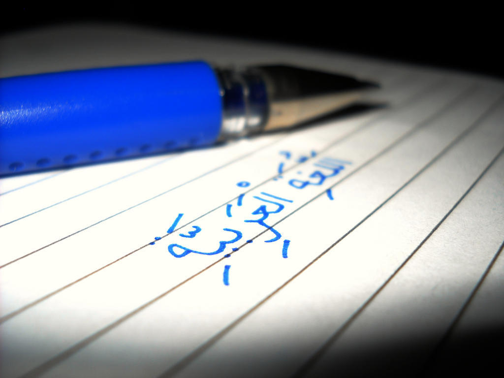arabic script written in blue pen, with an ink pen placed beside