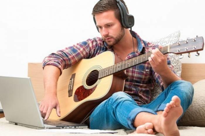A man learning the guitar online