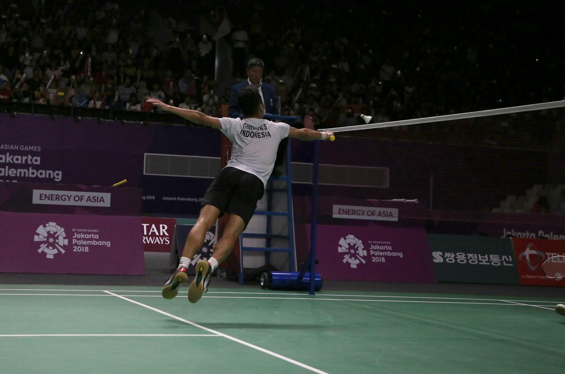 A badminton player leaping to make a net shot. 