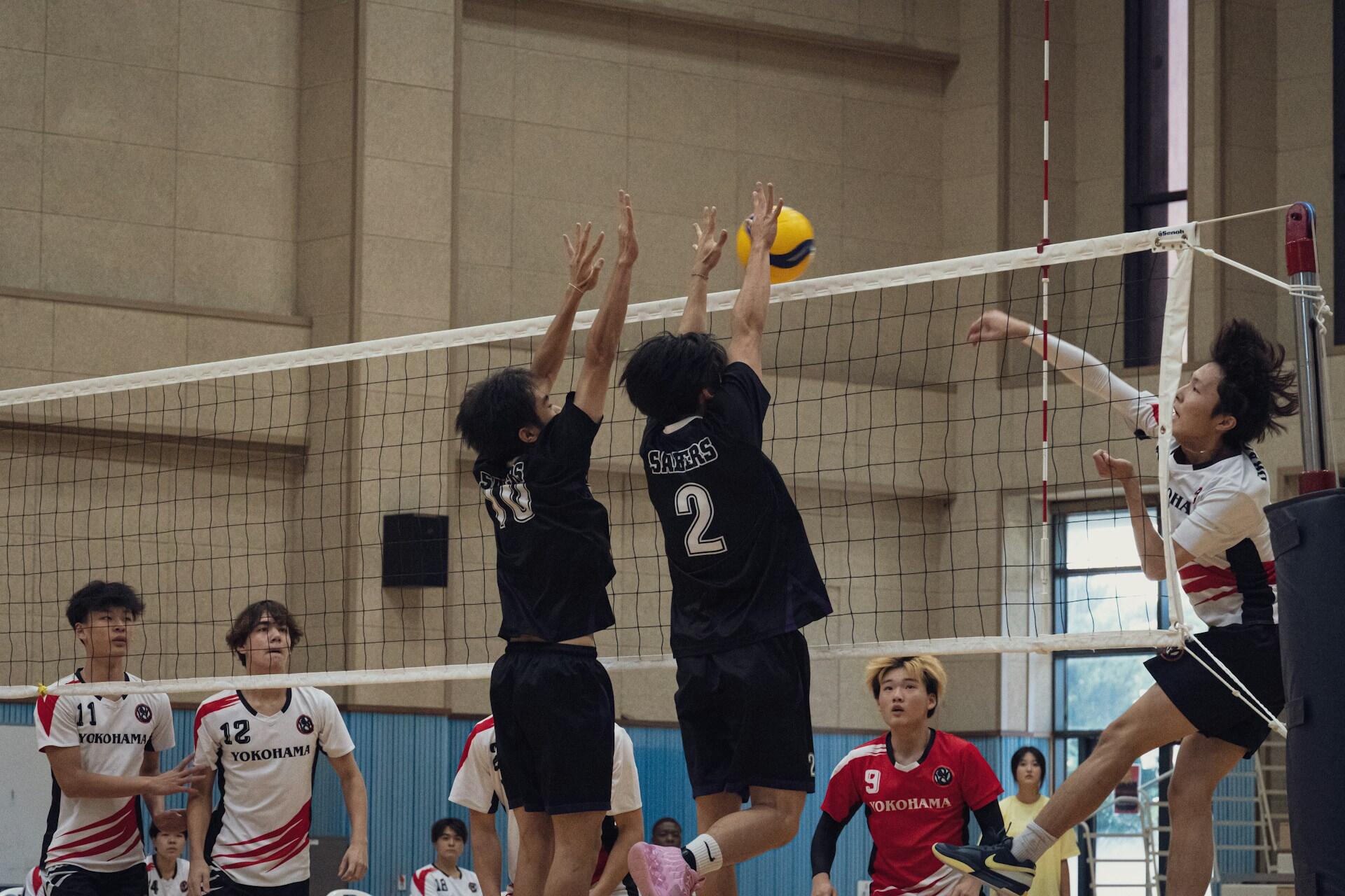 The opposite hitter blocking a volleyball hit.
