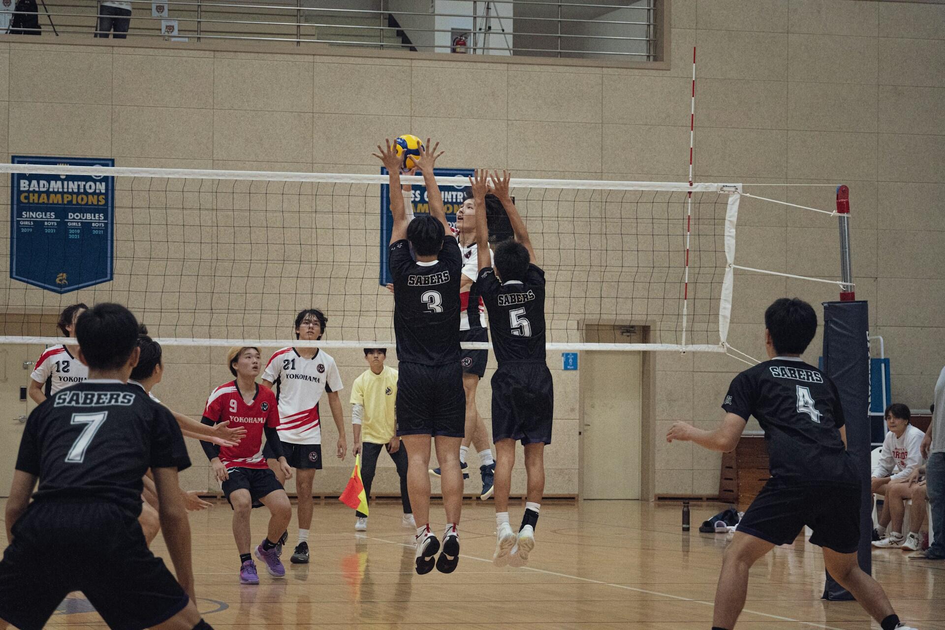 An opposite hitter and middle blocker prepare to block a hit.