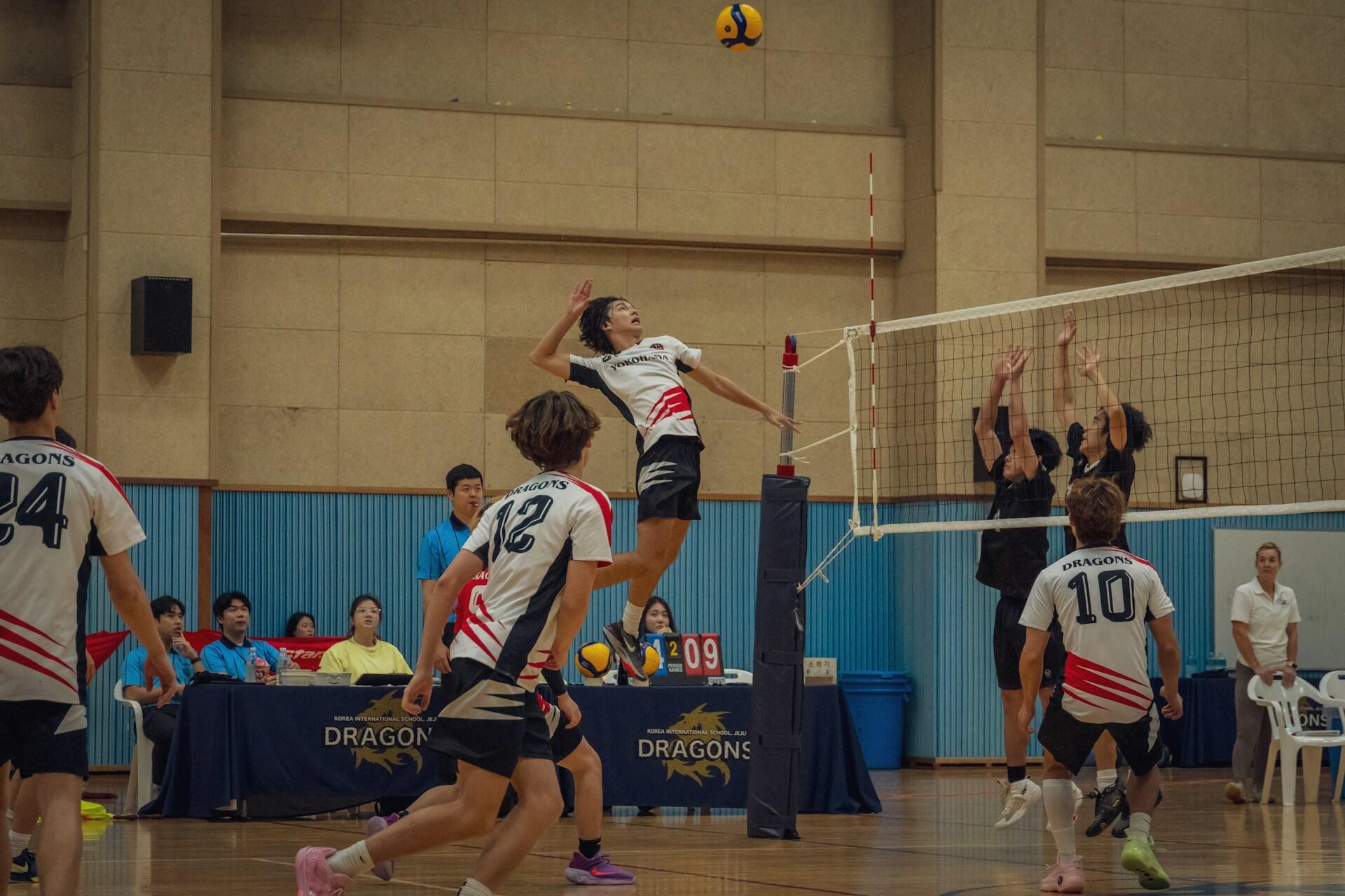 A volleyball outside hitter leaping to hit a ball.