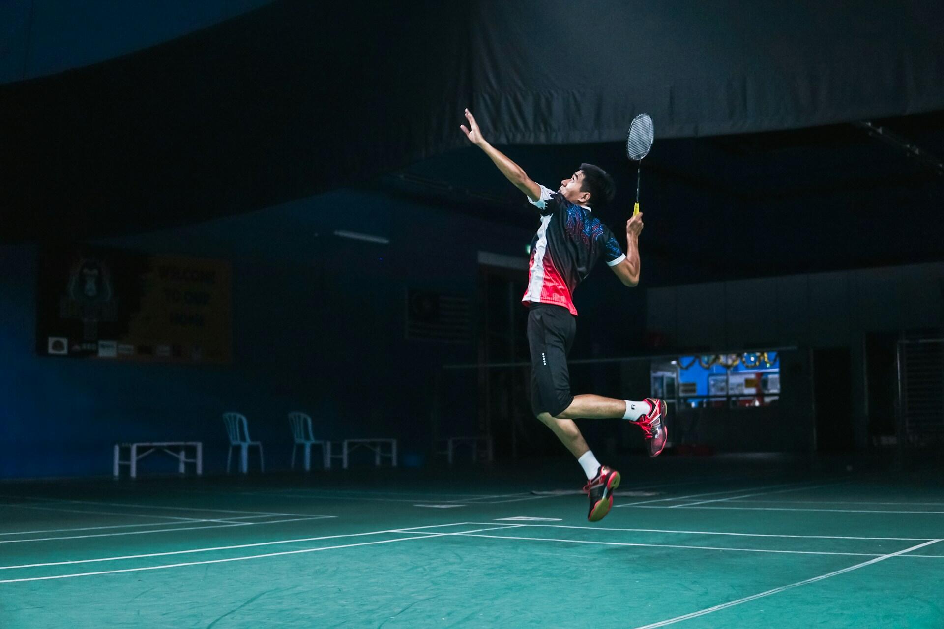 A badminton player leaping to make the shot.