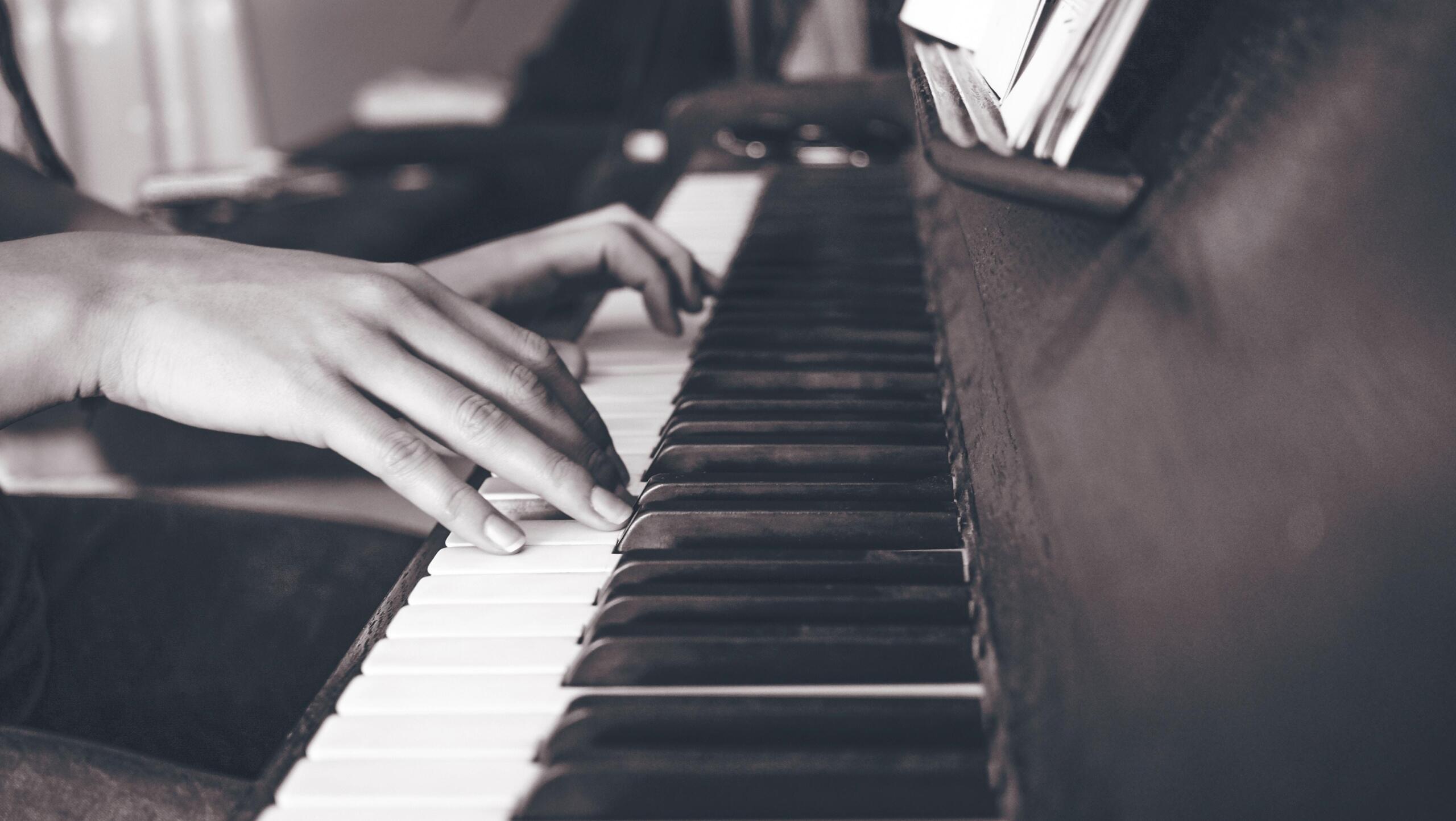 black and white image of a person playing the piano