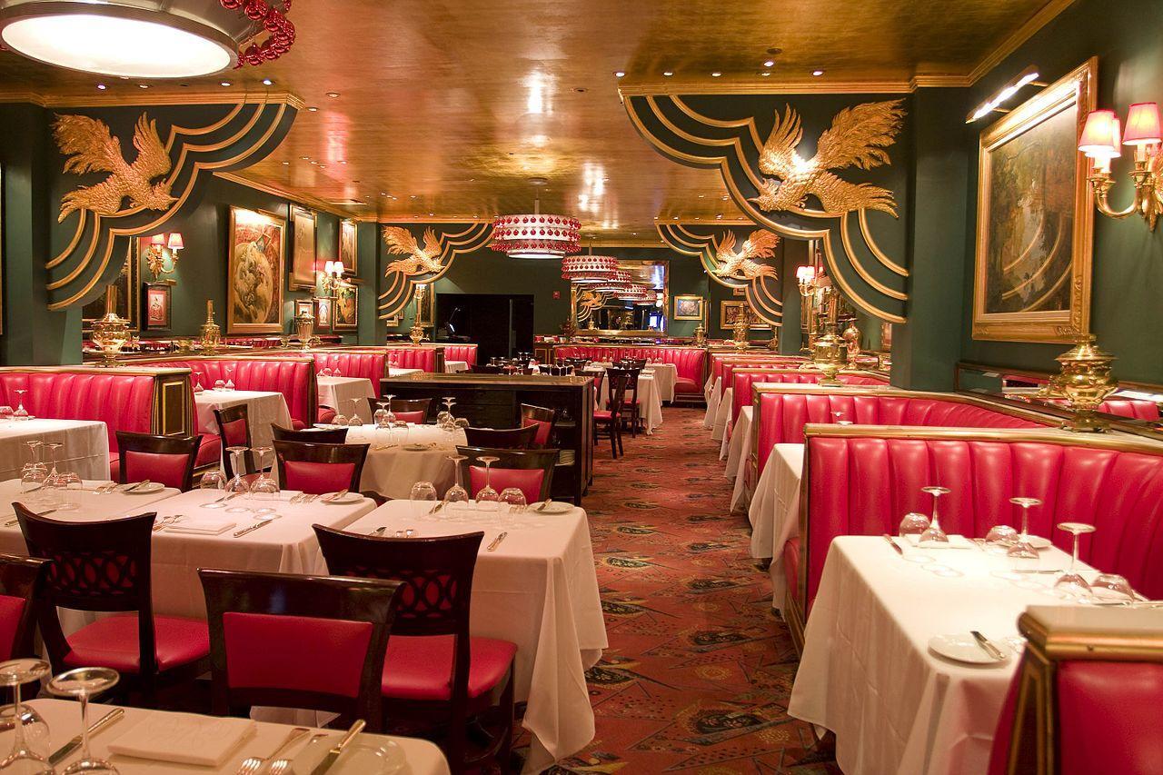 elaborate dining room with red table booths and green wallpaper