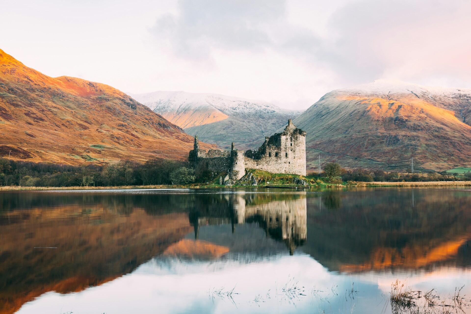 scottish landscape with a castle in the mountains overlooking a lake