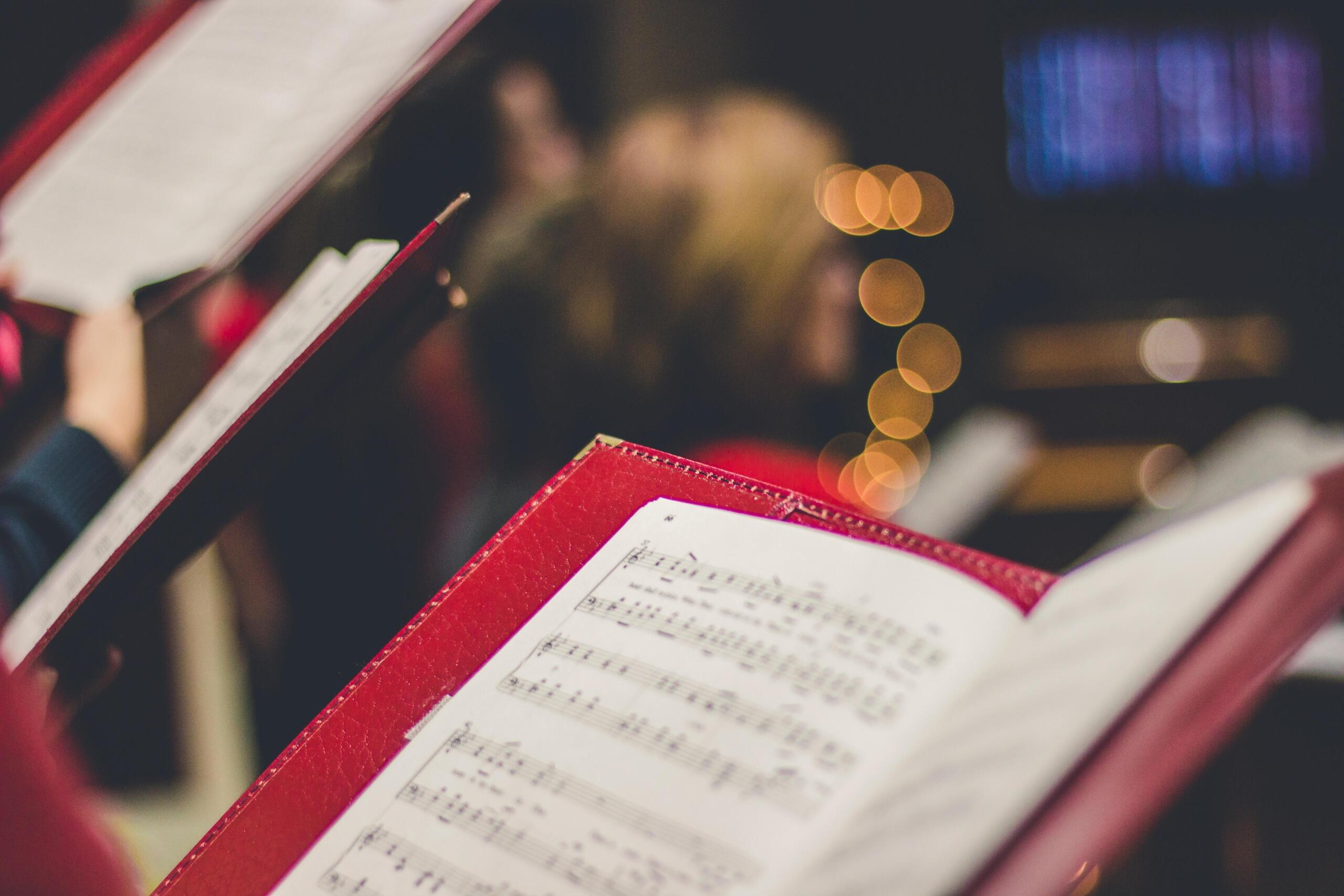 a red book open with sheet music inside