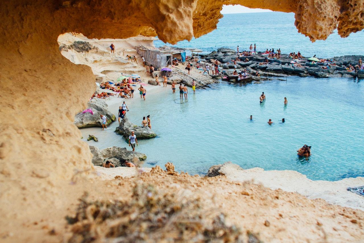 a sandy beach with people swimming