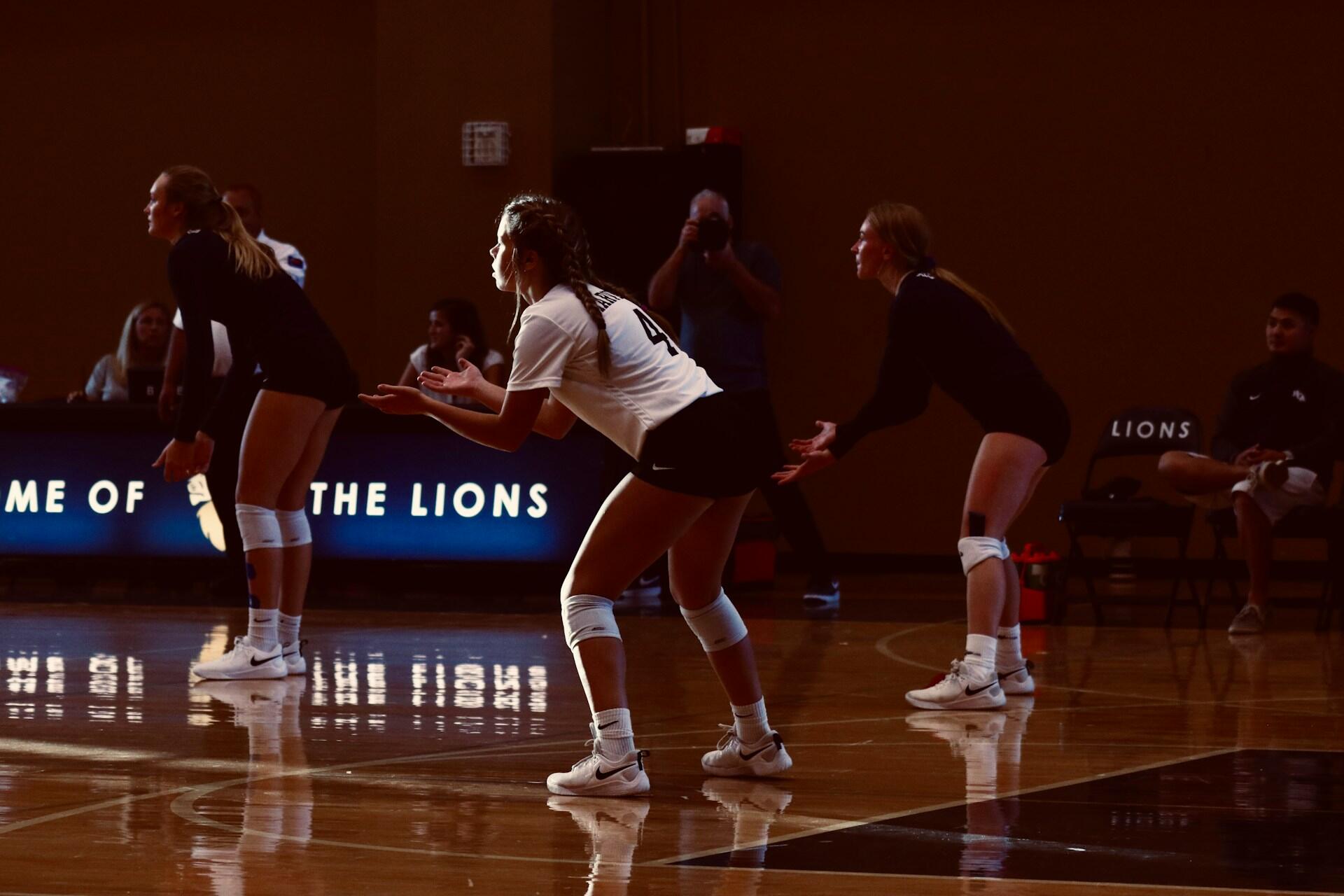 Volleyball players waiting for a serve.