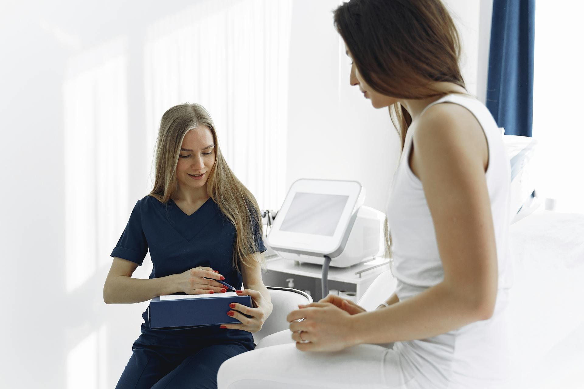 woman looking at clipboard with patient in background