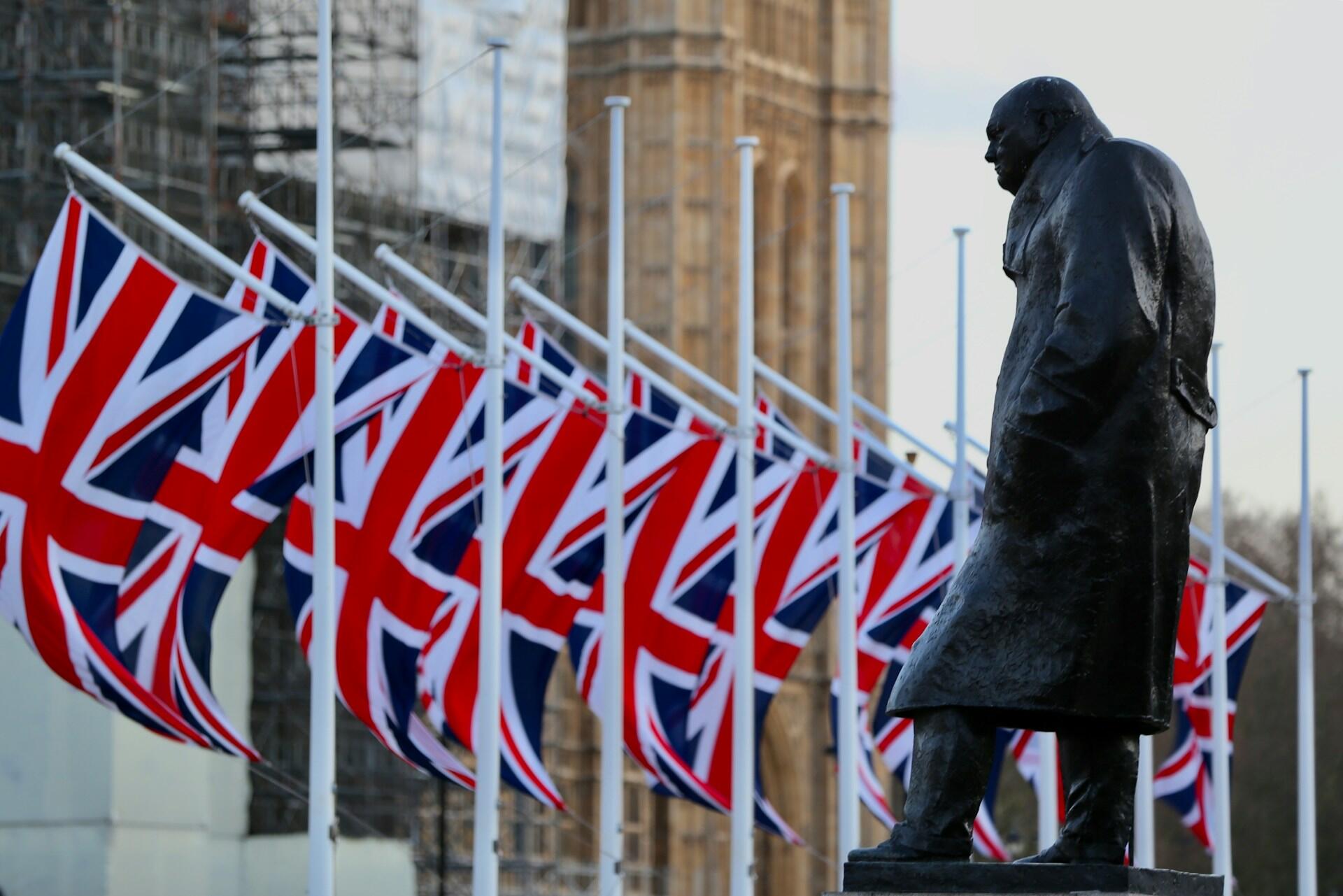 A row of British flags around a statue.