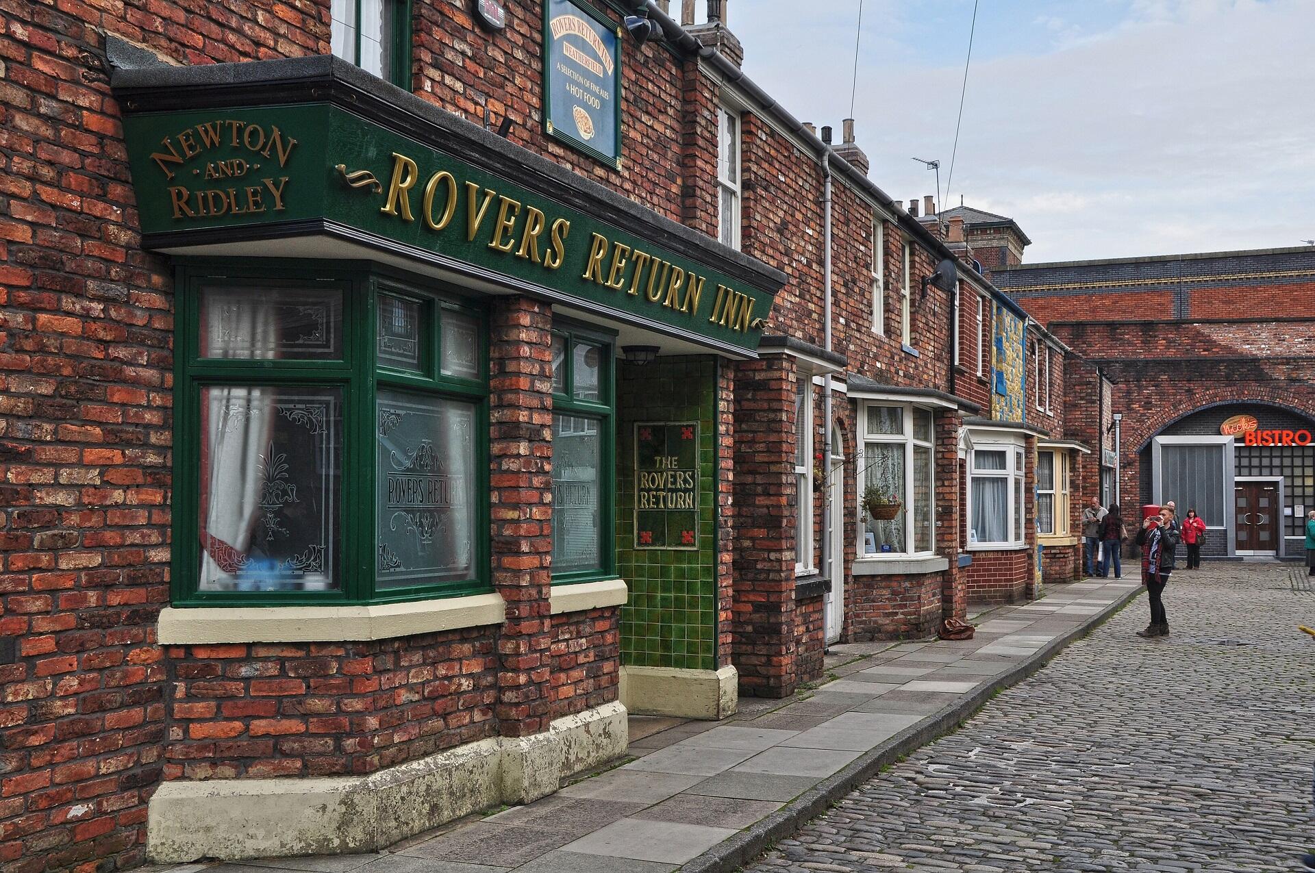 A cobblestone street lined with short brick buildings.