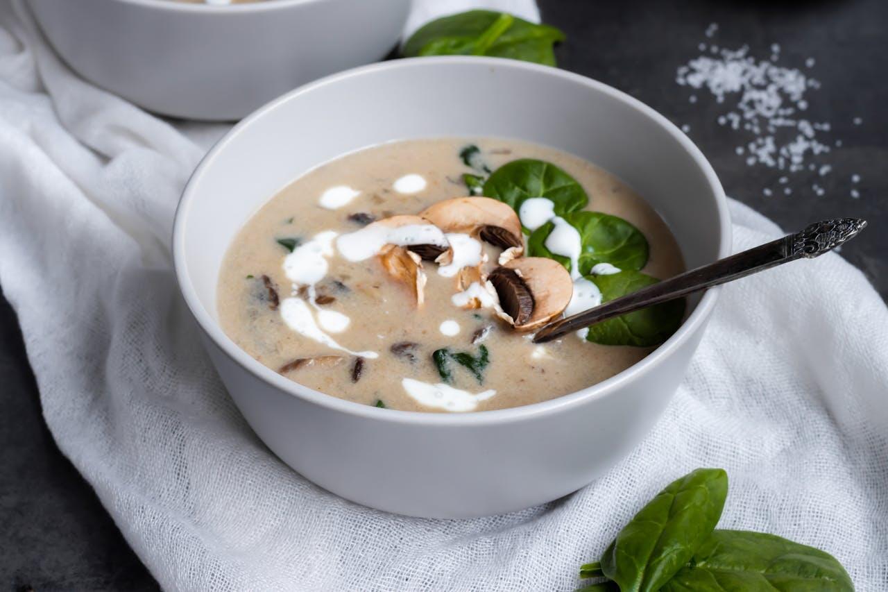 a bowl of mushroom soup with greens