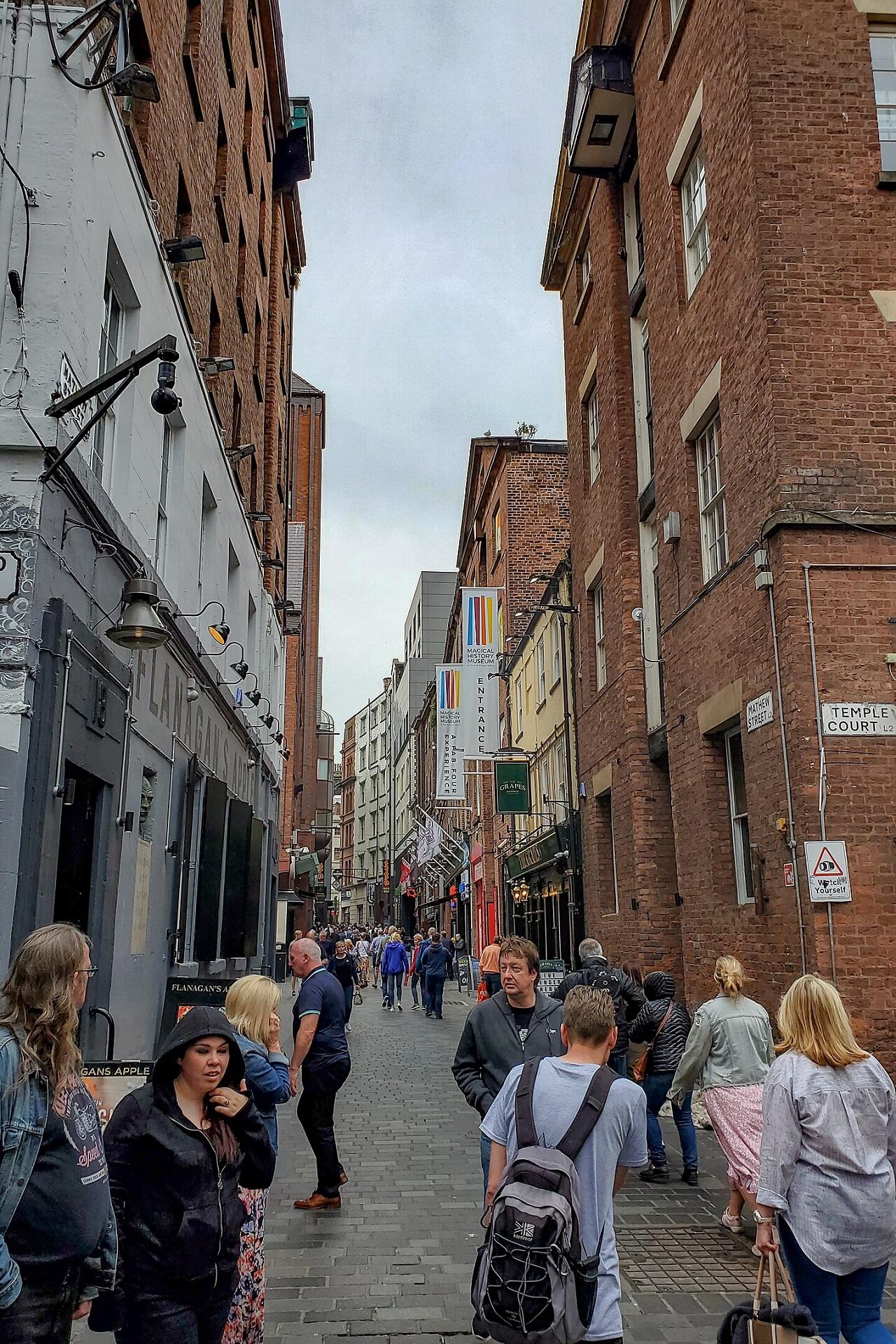 A narrow street with people milling about.