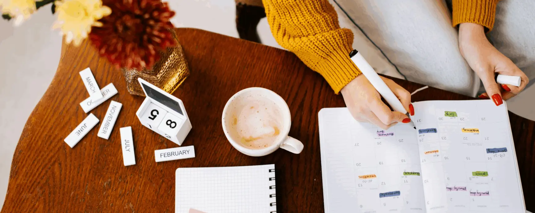 person working on a table with an agenda and a coffee