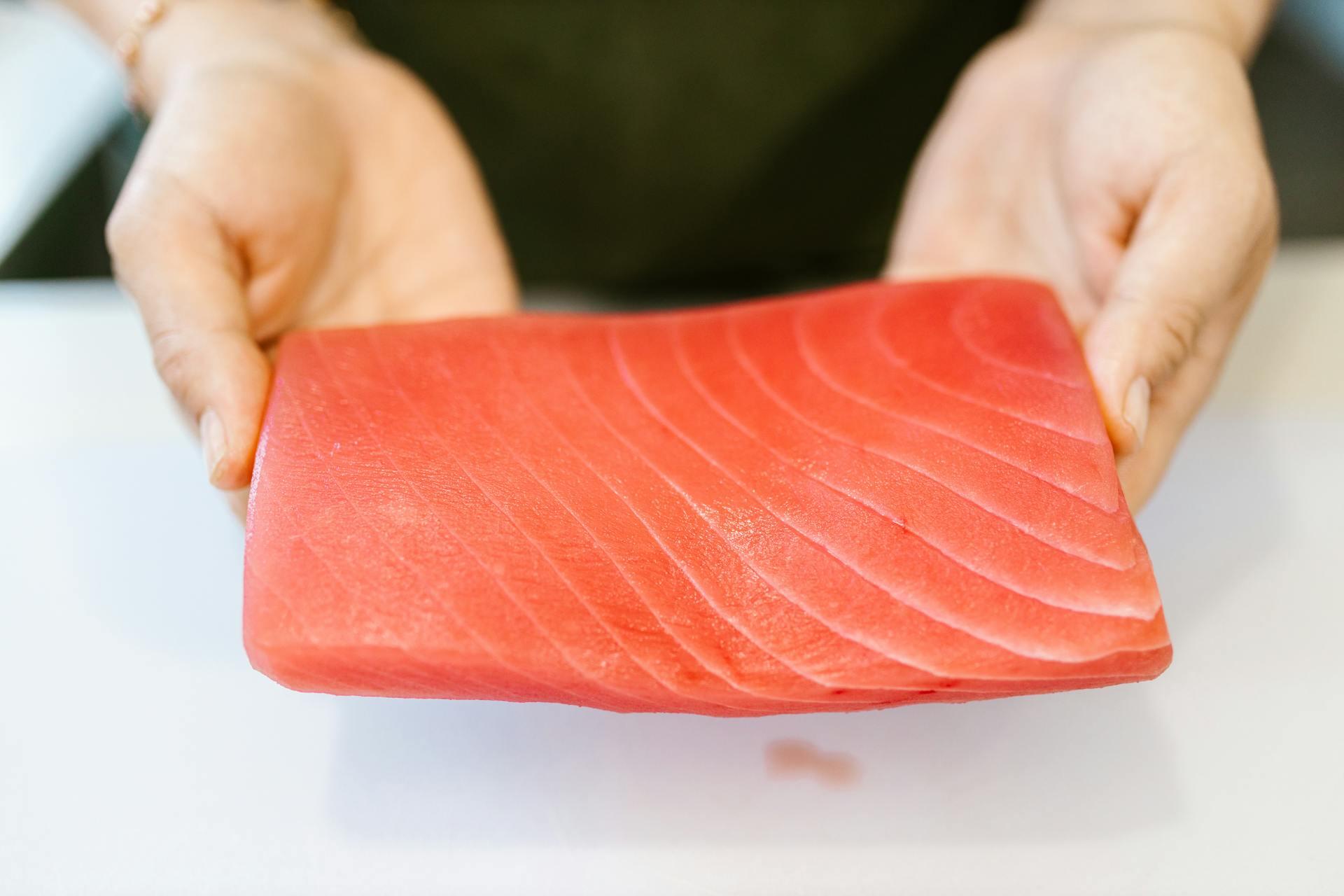 A slice of fish being held 