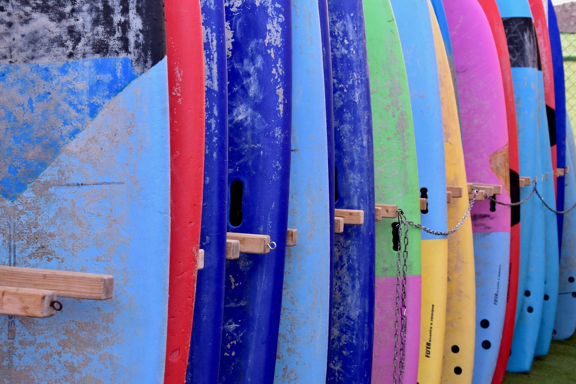 A colourful array of soft-top surfboards.