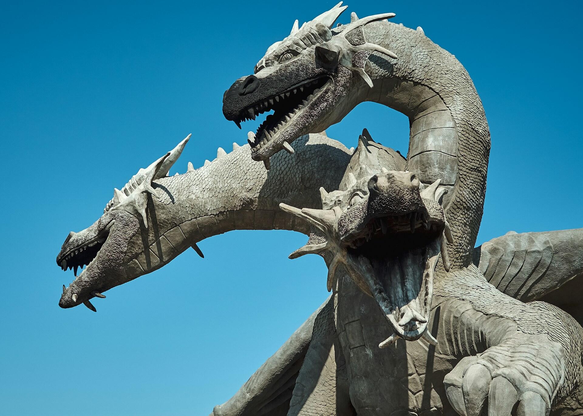 A three-headed dragon statue on a sunny day.