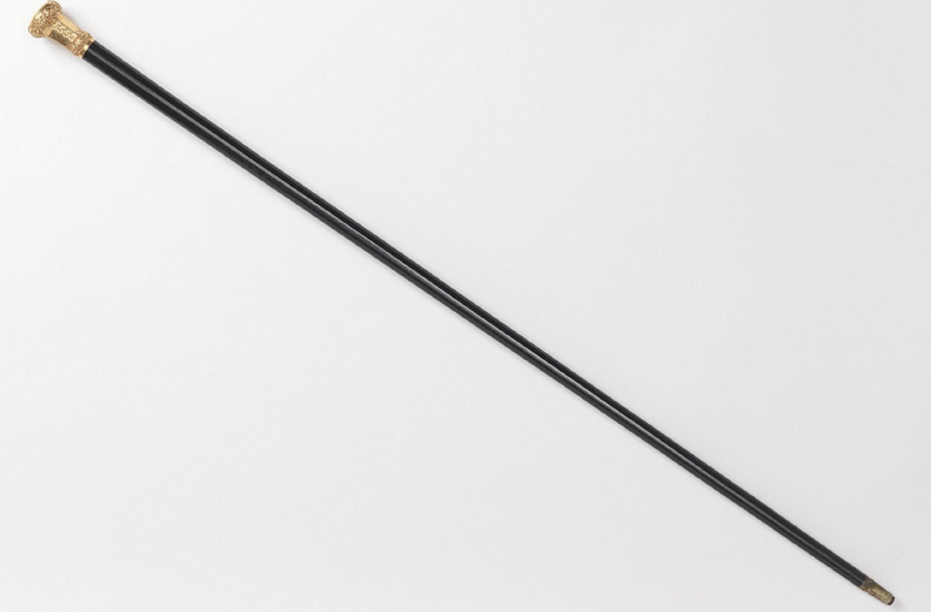 A black walking stick with a golden head.