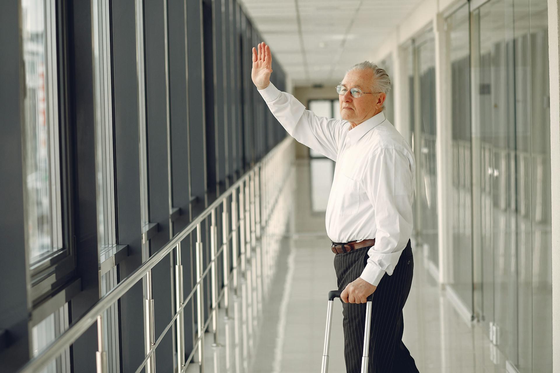 Old man waving goodbye at airport 