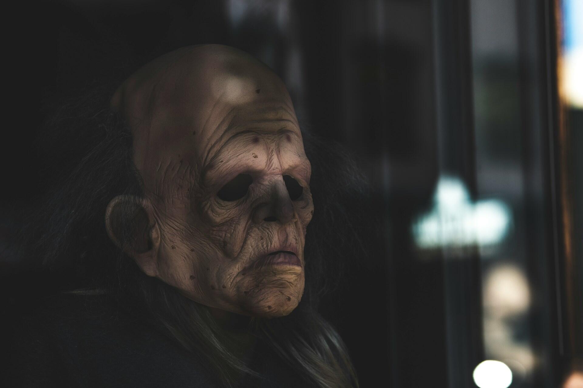 A deformed, ugly face lurks in the shadows.