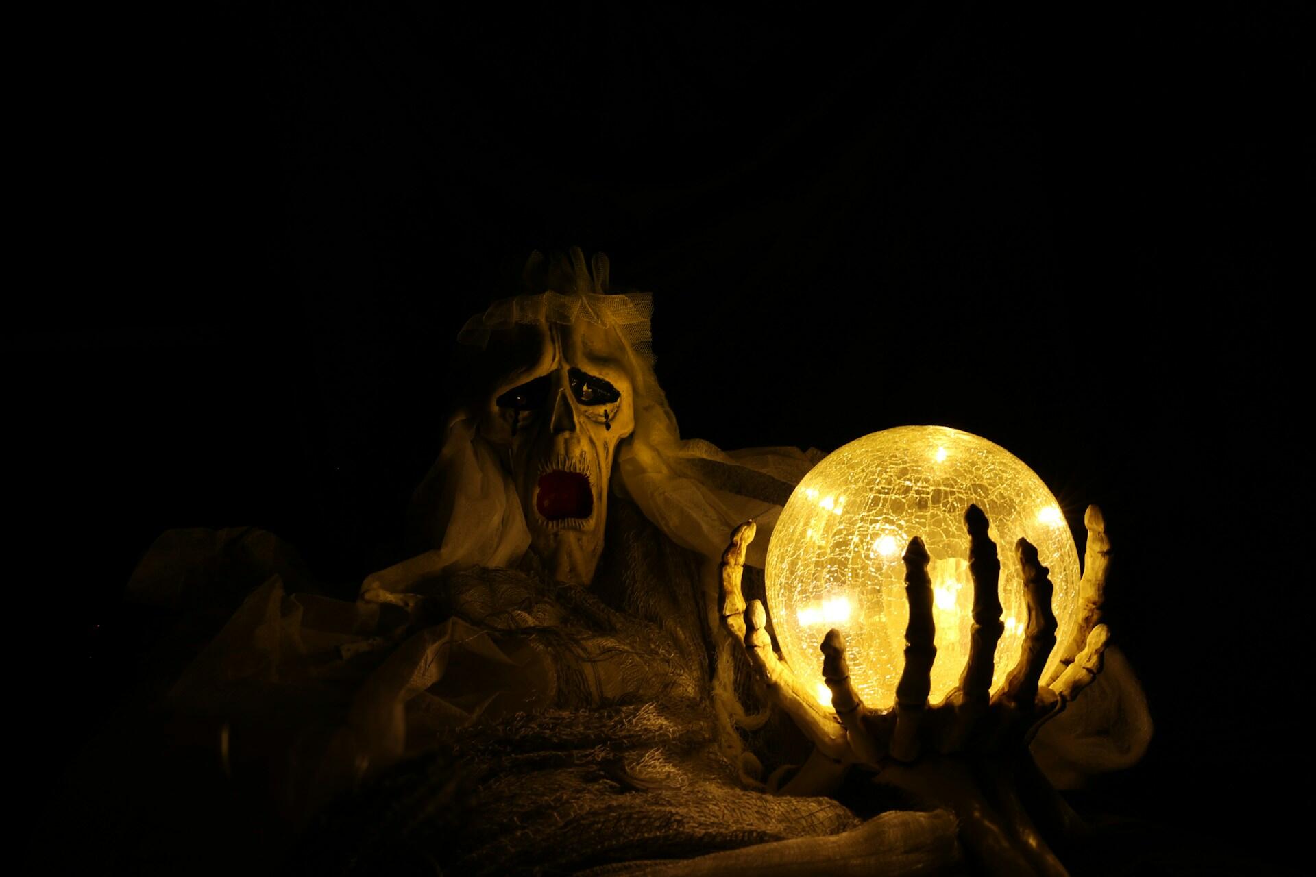 A skeleton holds a lighted orb.