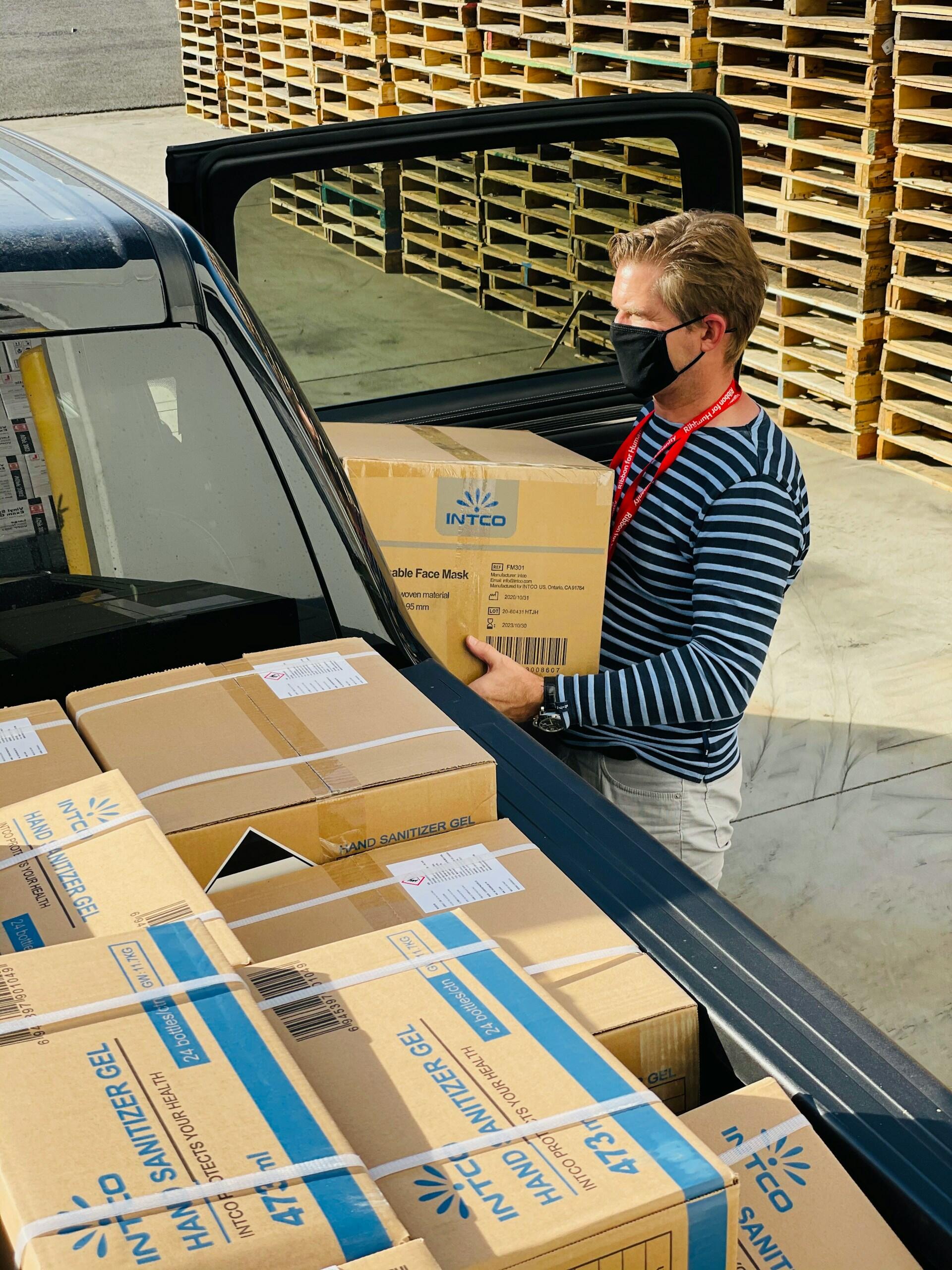 A person loads boxes into a pickup truck. 