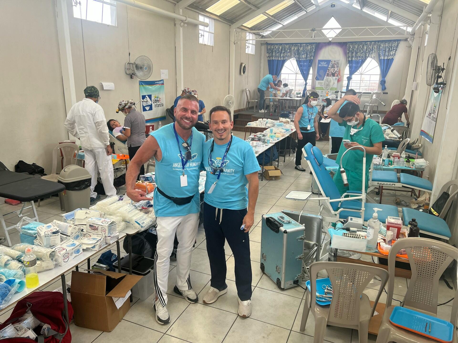 Two people wearing light blue shirts in a donation centre