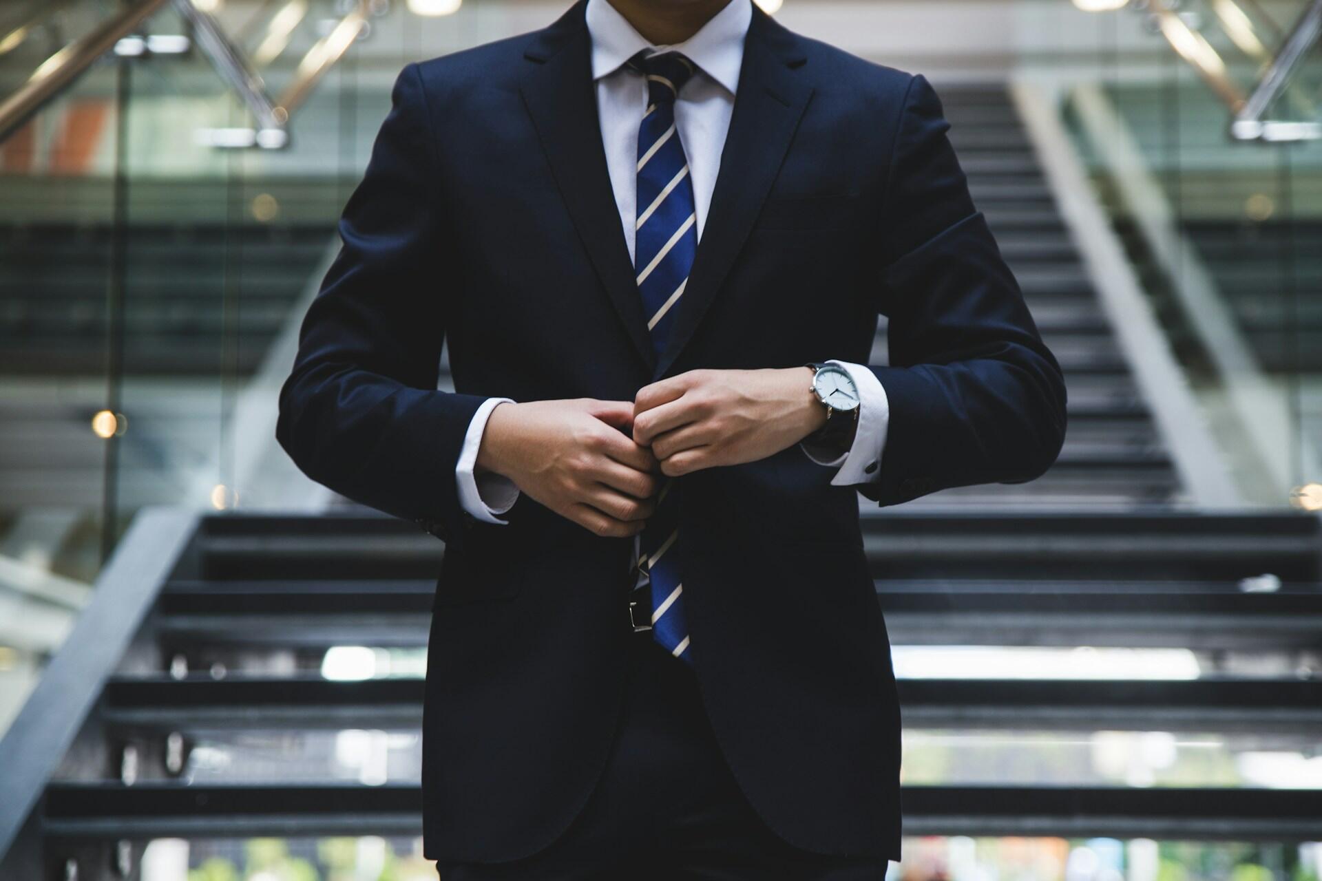 A man wearing a business suit on a staircase.