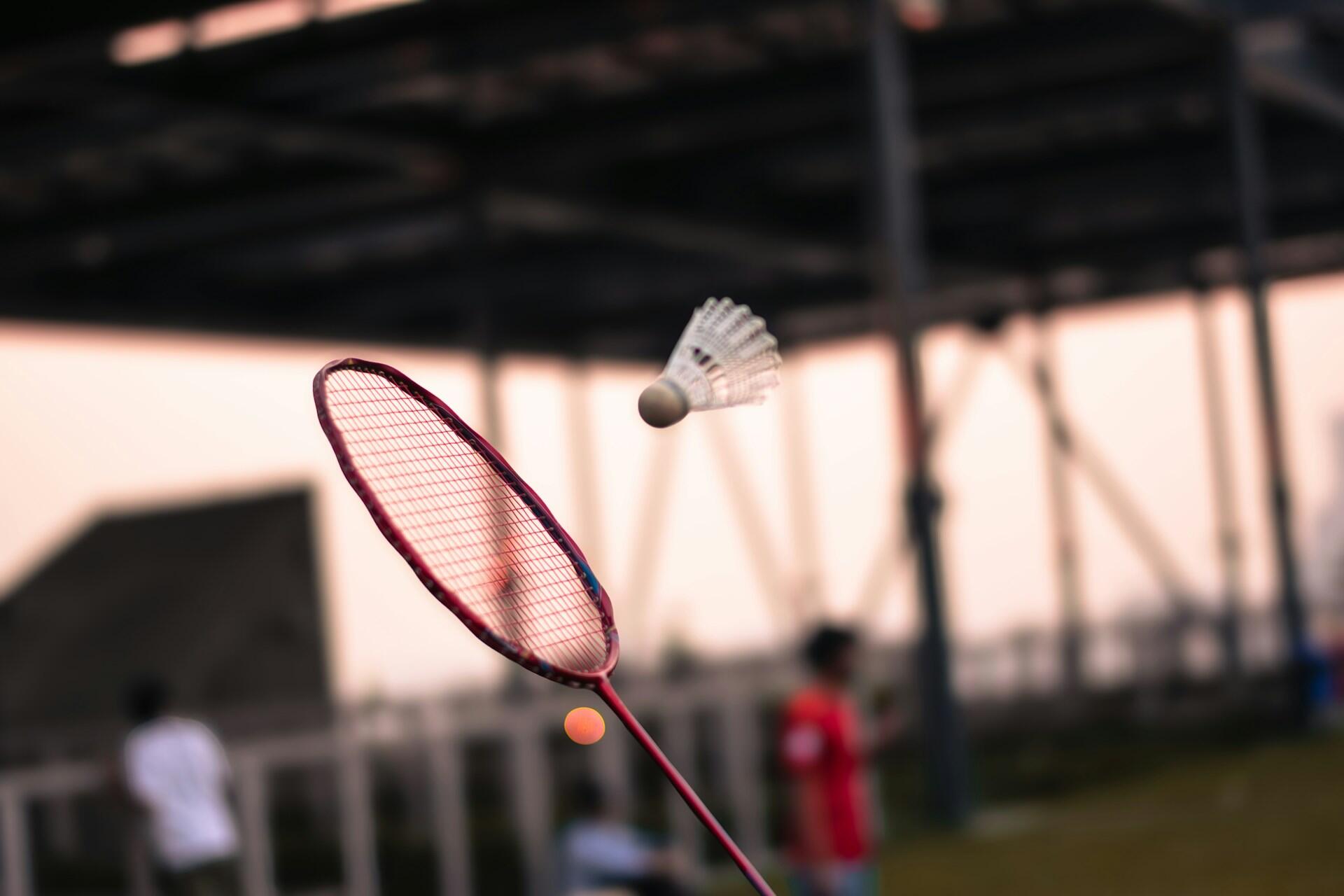 A badminton racquet receiving a shuttlecock.