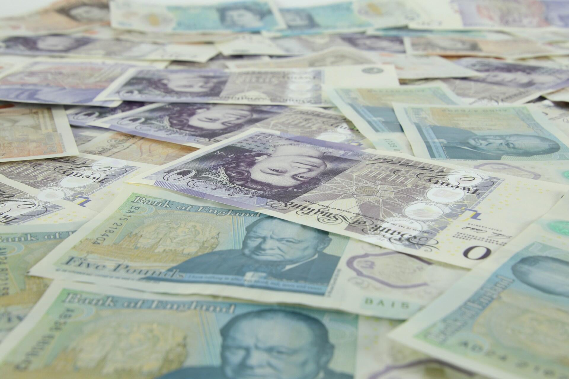 A scattering of British pound sterling notes.