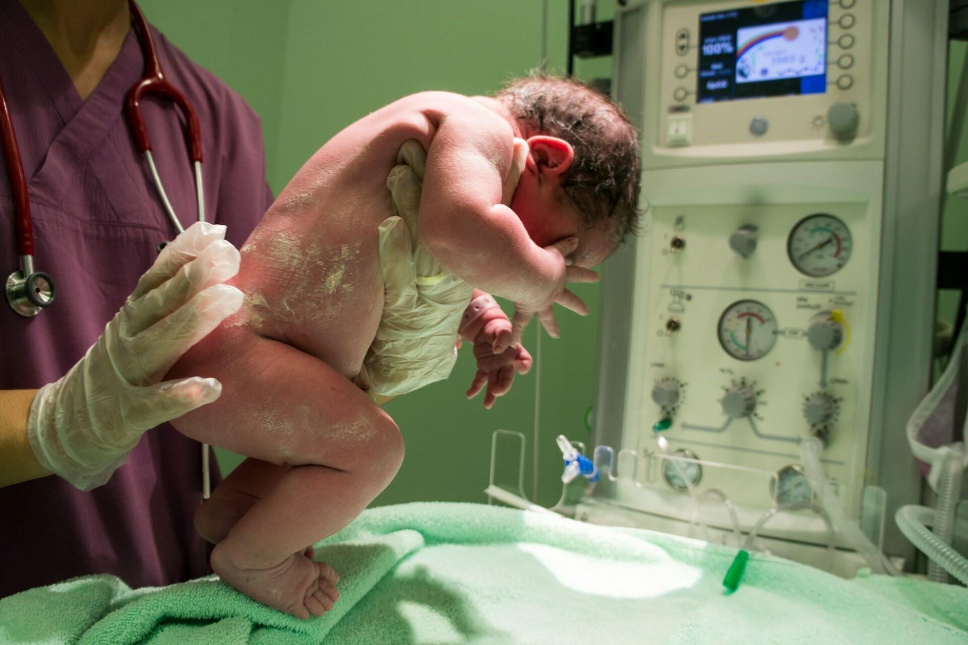 A nurse holding a newborn baby.