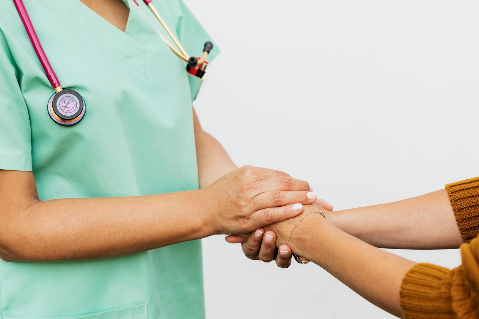 a nurse holding the hands of a patient