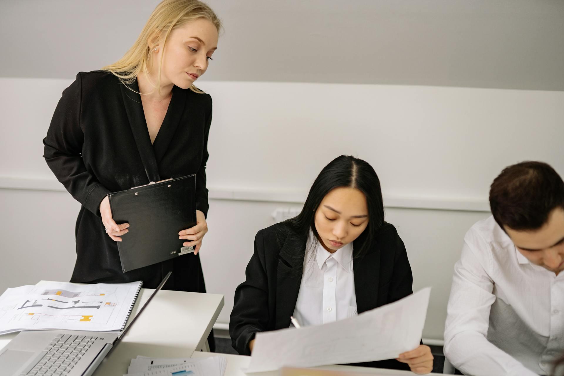 Woman looking over shoulders of co workers