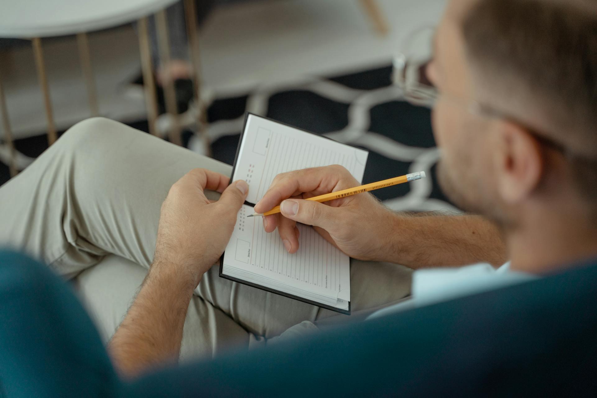 man writing in a journal