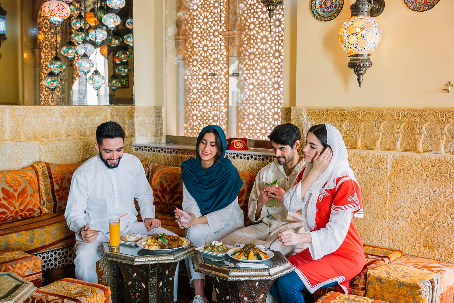 A group enjoying a meal together in a beautifully decorated restaurant, with traditional dishes displayed on a low table.