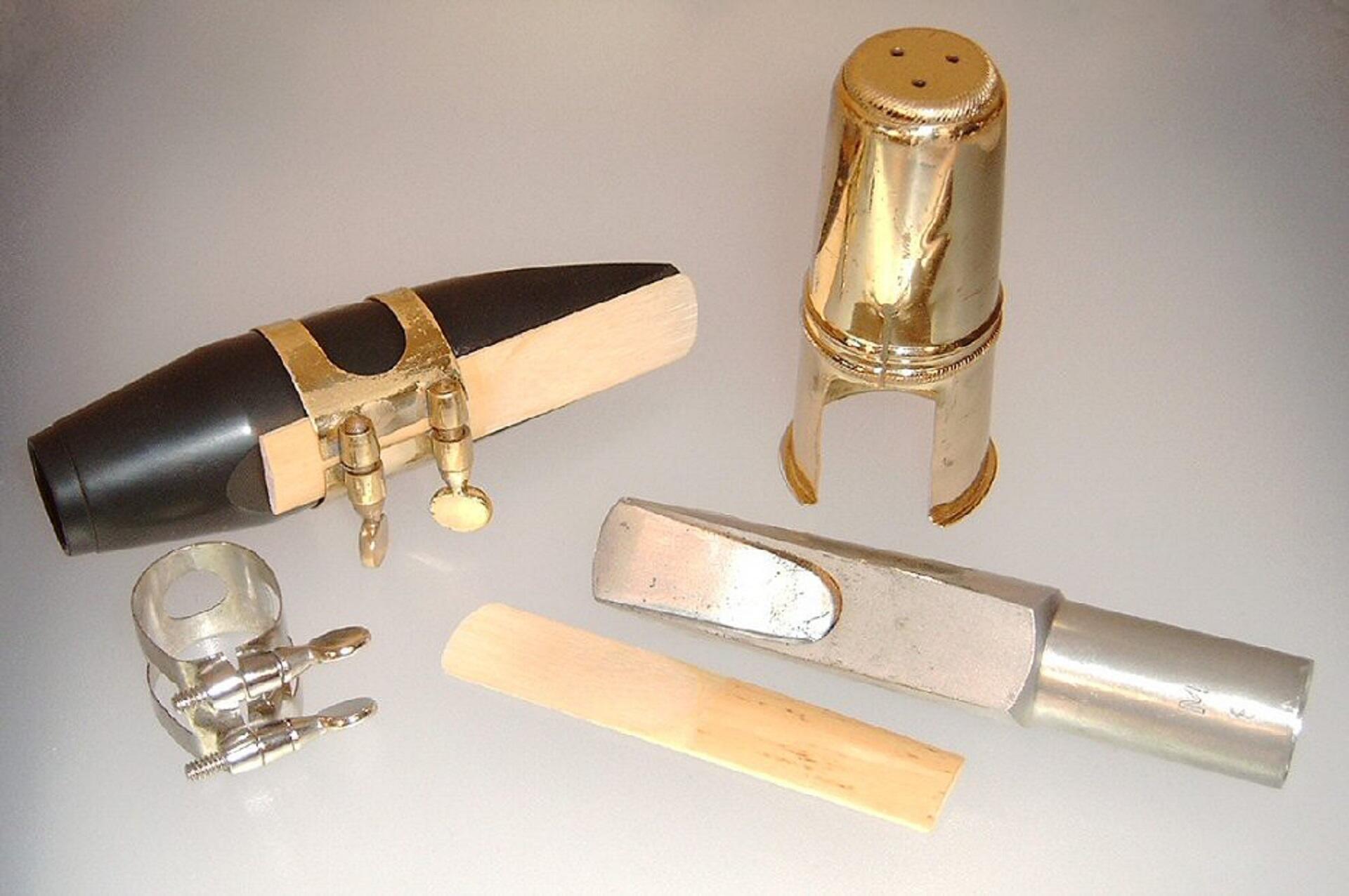 A saxophone mouthpiece including cover, ligature, and reed.