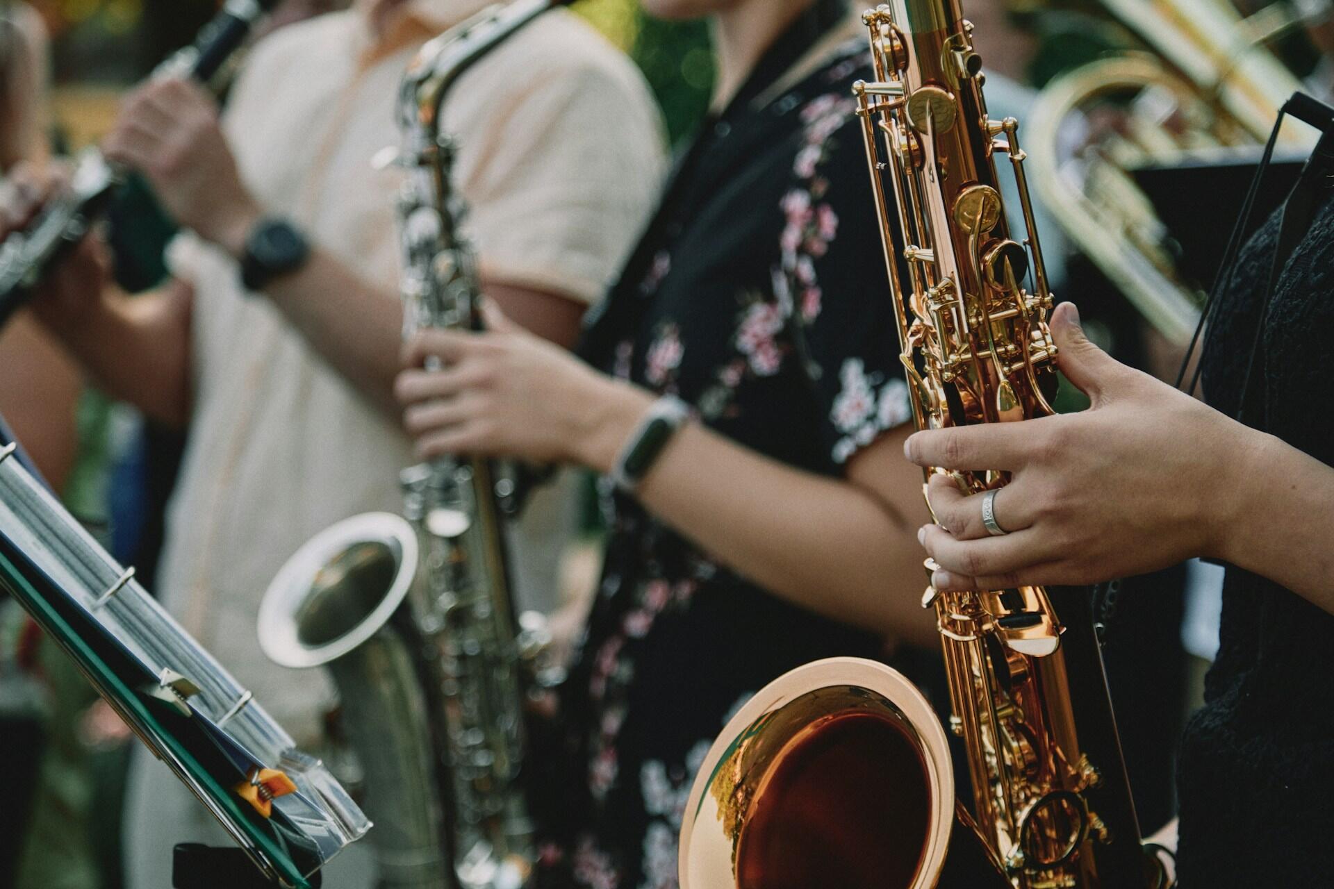 People in a row playing the saxophone.
