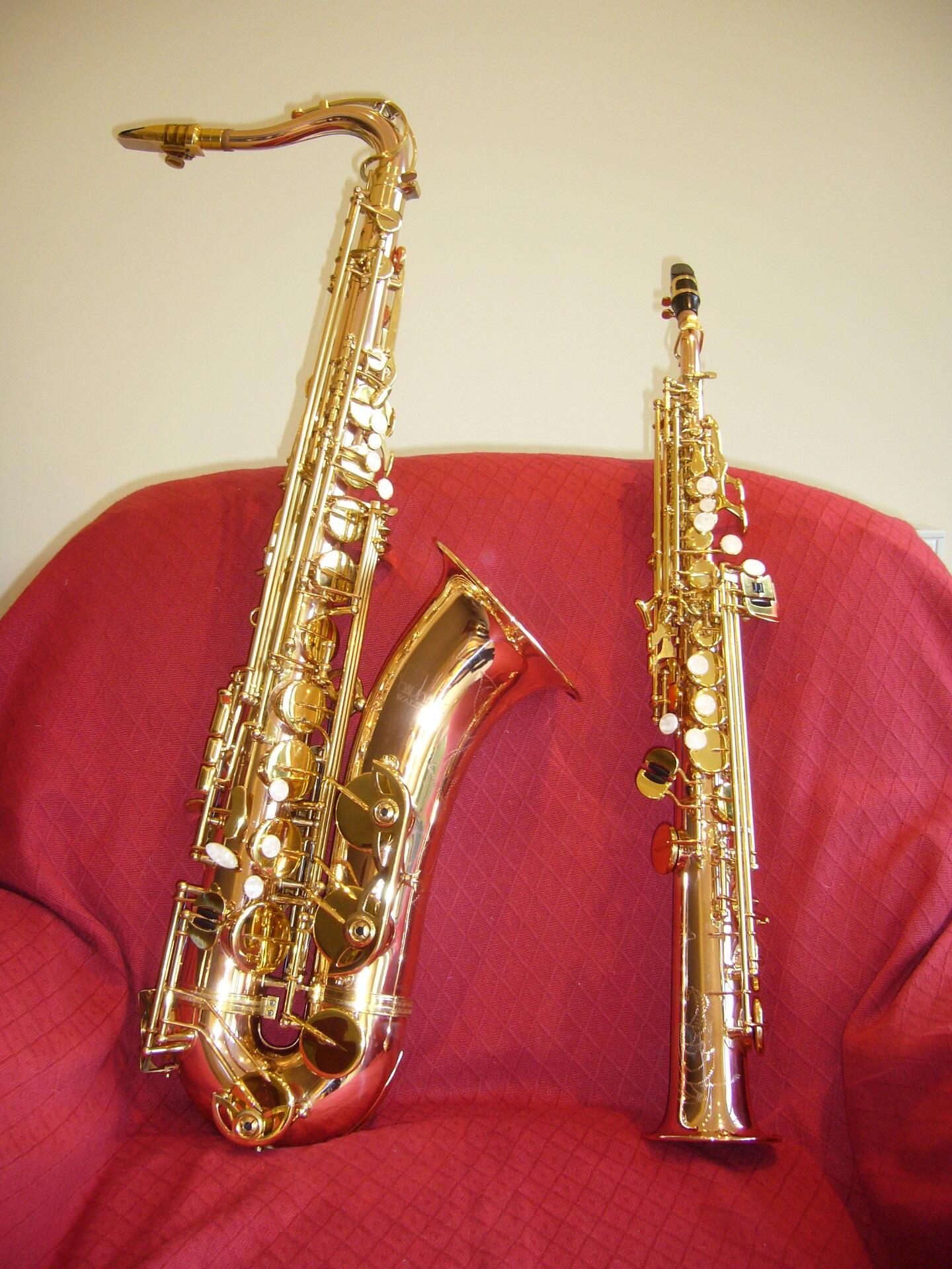 Two saxophones on a red chair.
