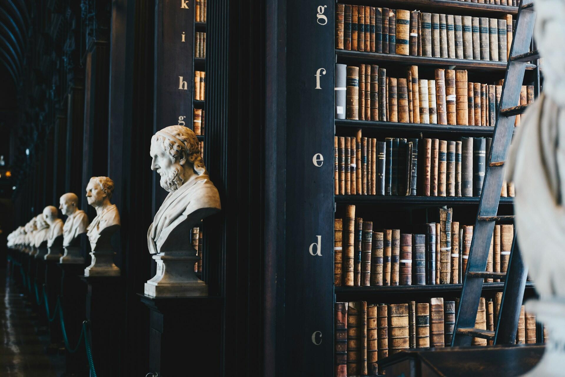 library lined with sculptures of famous people through history