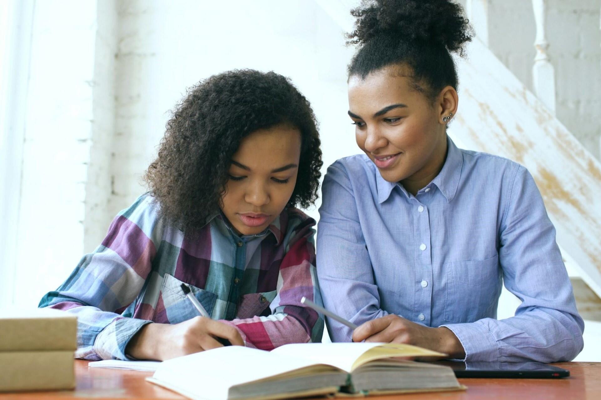A girl tutoring another girl.