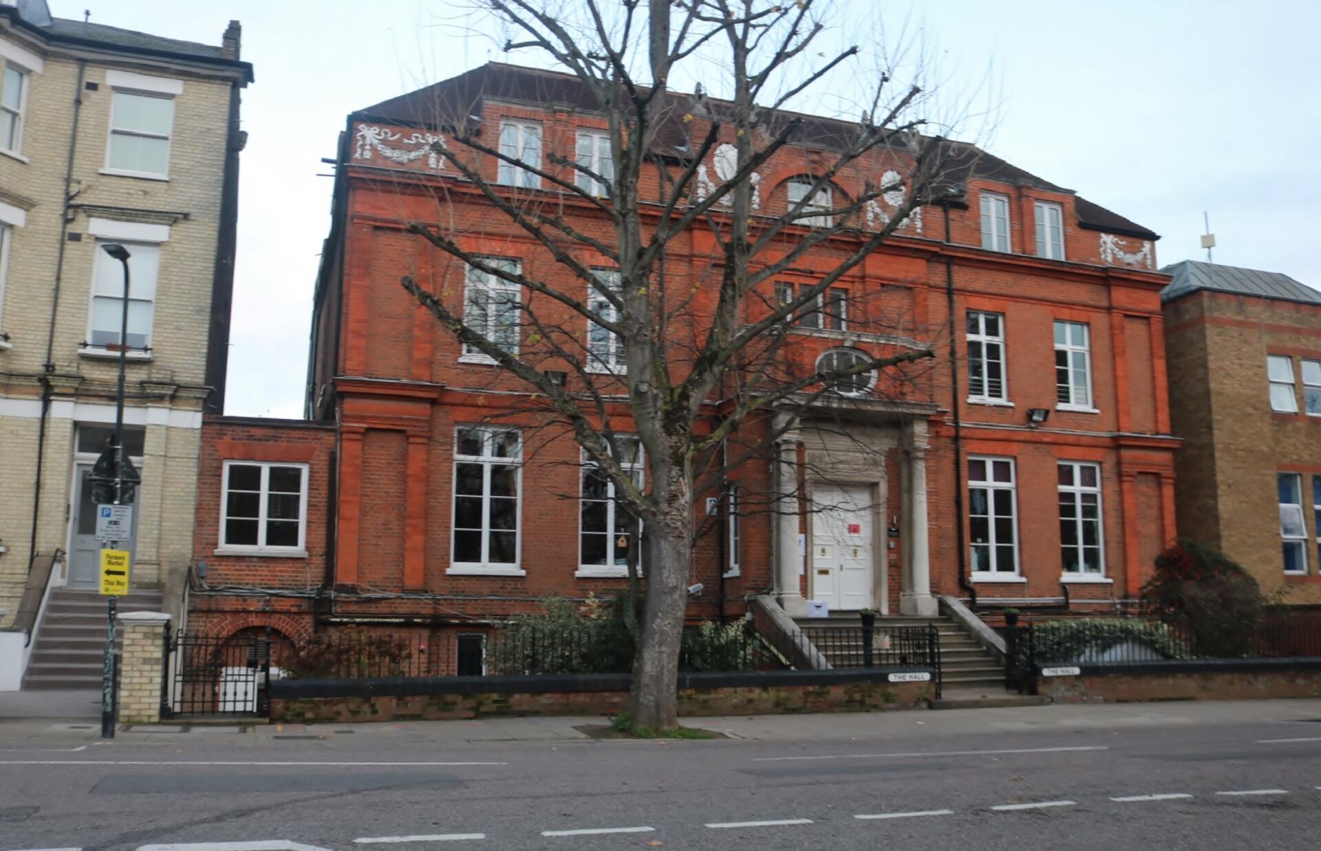 A tall red brick building with a white door.