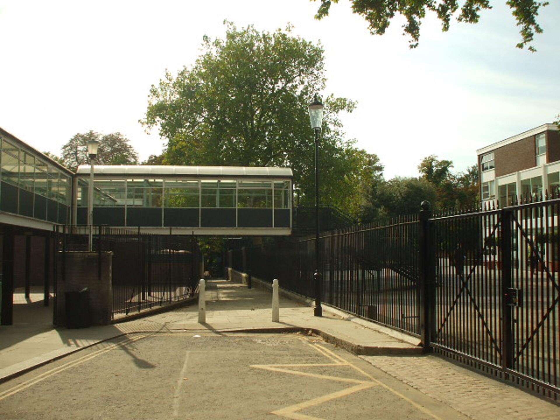 A school building with a flyover jutting over a walkway.