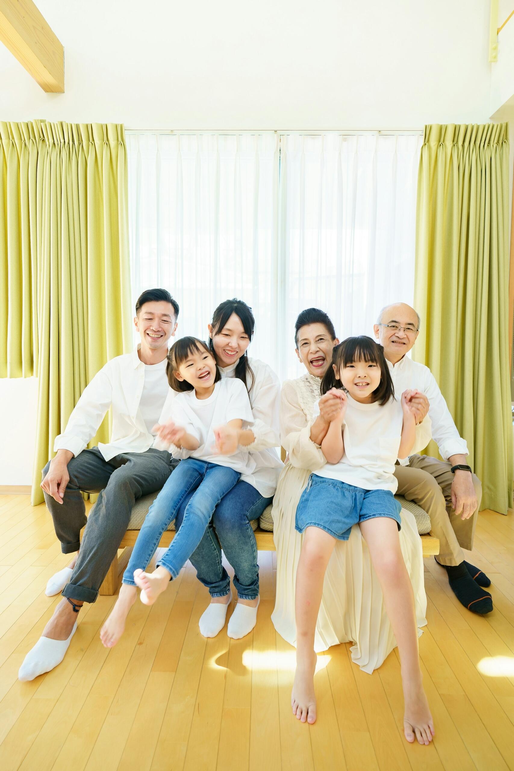 A family, casually dressed, poses in a well-lit room. 