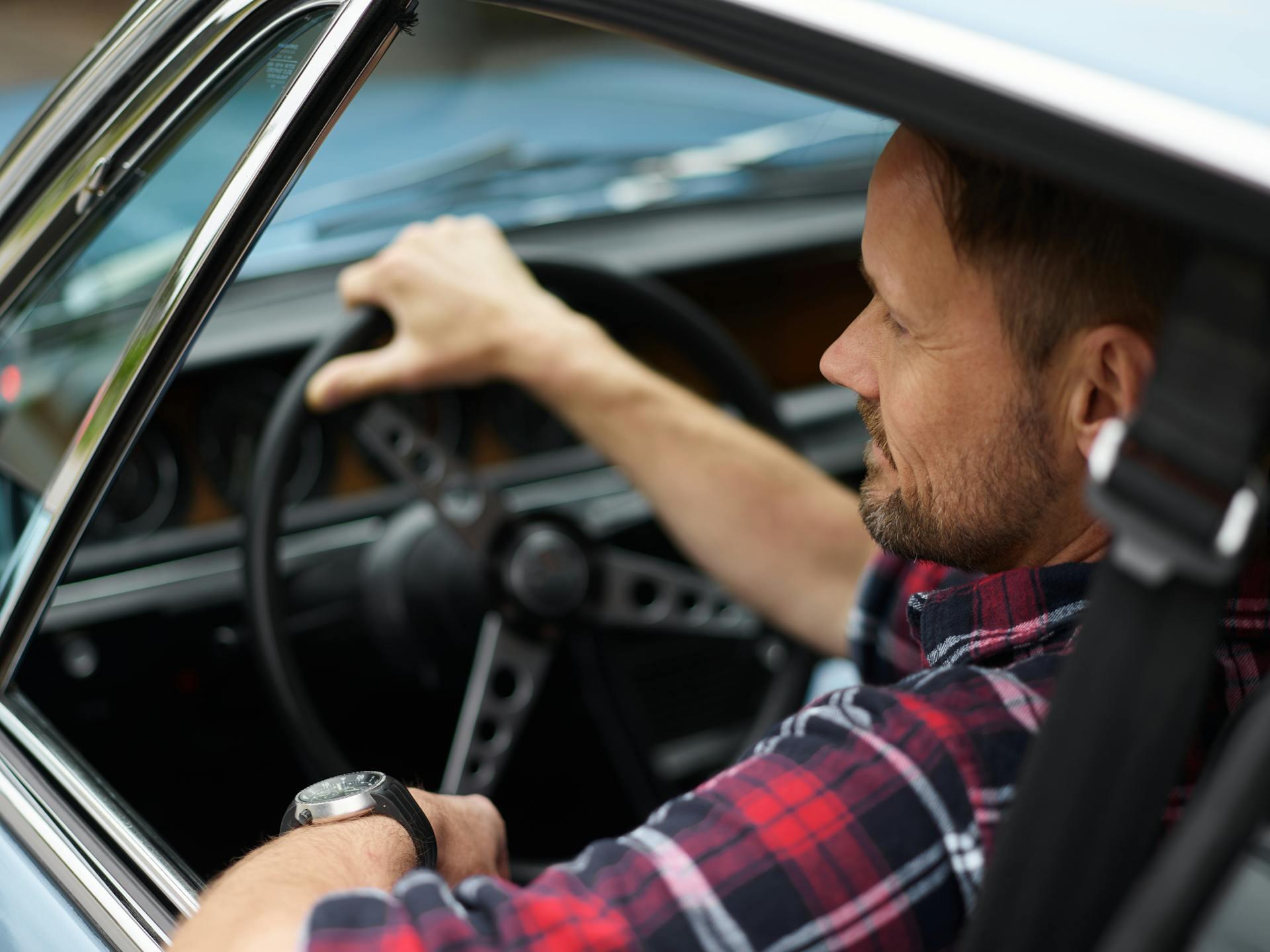 driver in the driver's seat of a classic car