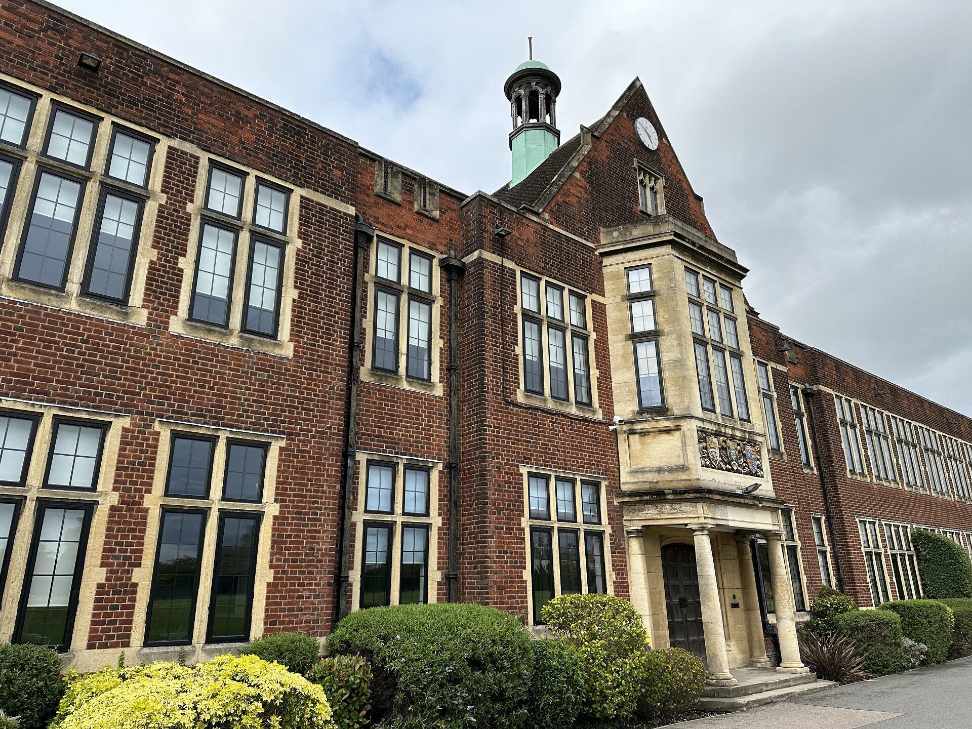 A red brick building with a white portico around its entrance.