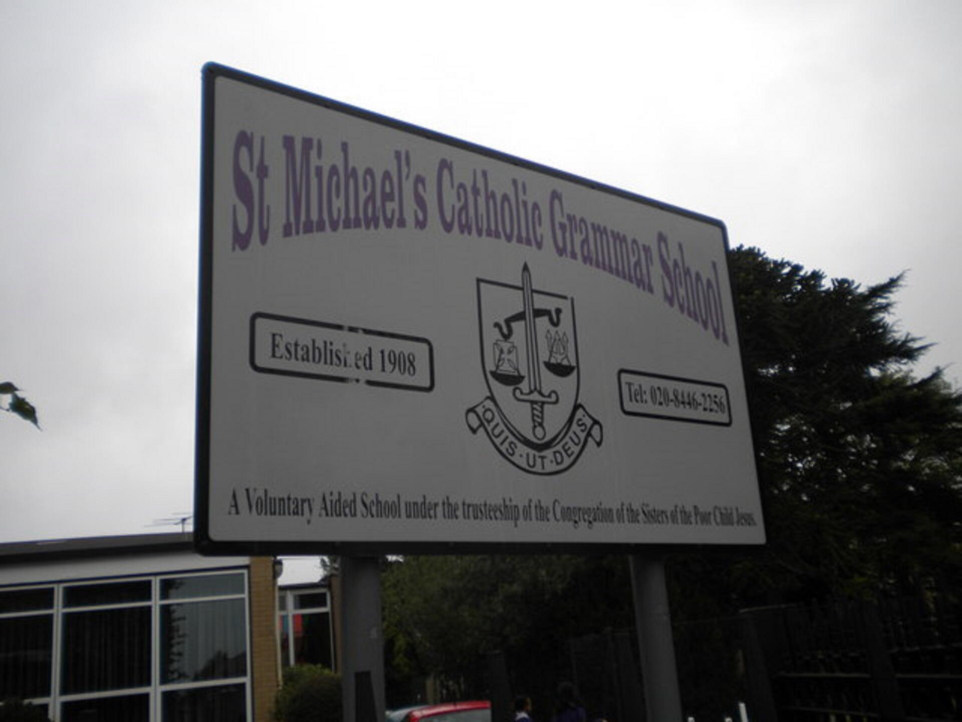 A white and purple sign in front of a building.